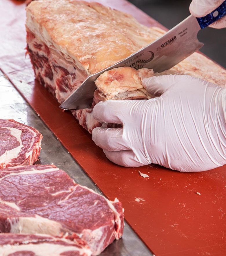 Metzger schneidet Fleisch in Scheiben in der Metzgerei von GROMA